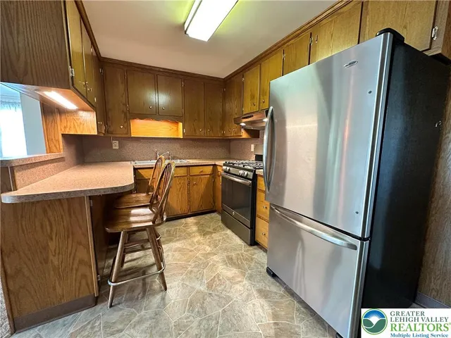 a kitchen with stainless steel appliances a refrigerator and a counter