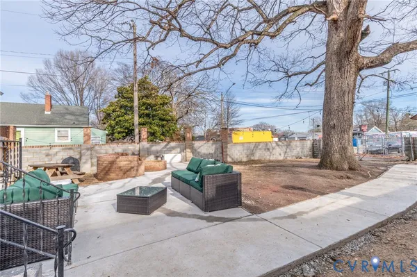 a view of a patio with couches and table and chairs and potted plants