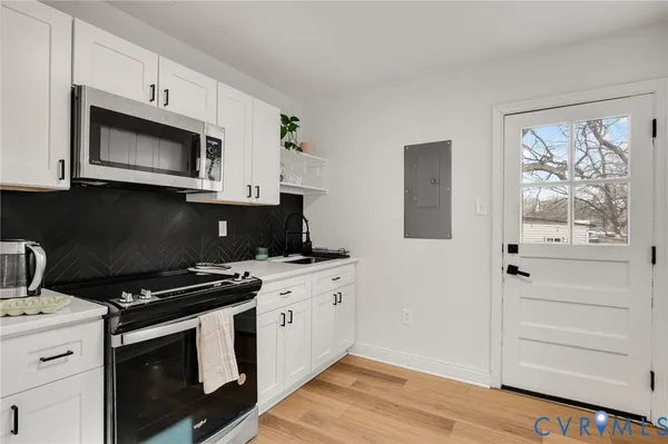 a kitchen with stainless steel appliances a stove microwave and cabinets