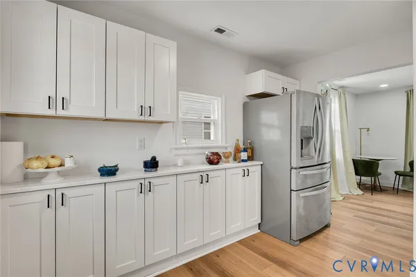 a kitchen with cabinets and wooden floor