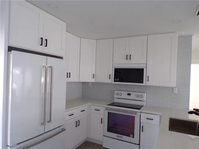 a kitchen with cabinets stainless steel appliances and a counter space