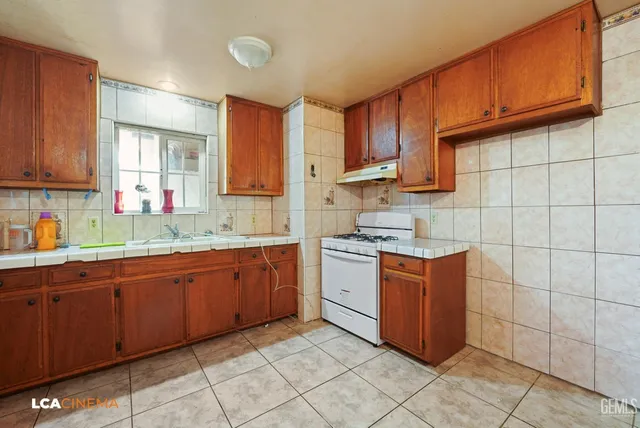 a kitchen with stainless steel appliances granite countertop a sink counter space cabinets and a large window