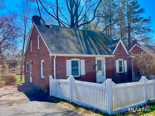 a view of a house with wooden fence next to a road