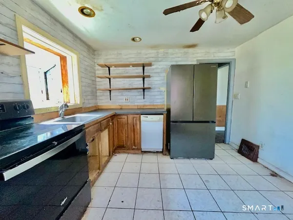 a large kitchen with stainless steel appliances granite countertop a sink and cabinets