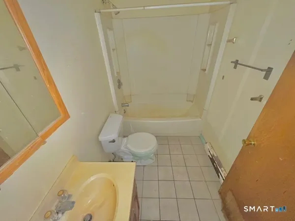 a bathroom with a granite countertop bathtub sink and toilet