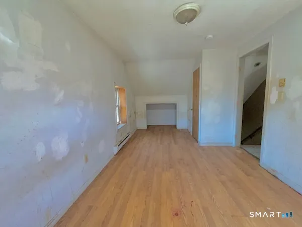 a view of empty room with wooden floor