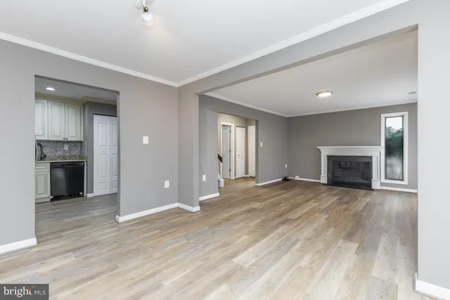 a view of empty room with wooden floor and fireplace