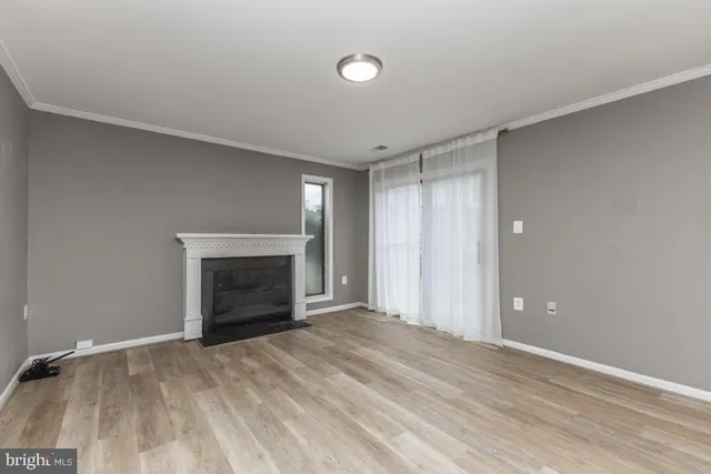 a view of an empty room with a fireplace and a window