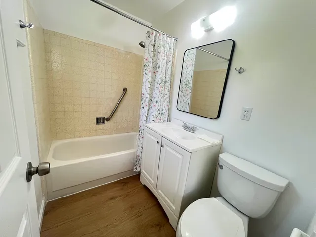 a view of empty room with wooden floor and windows