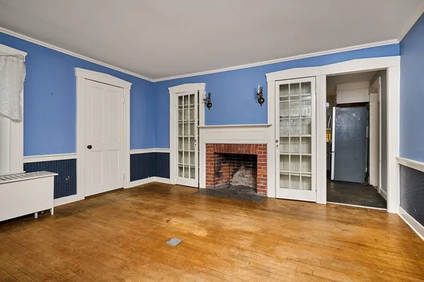a view of an empty room with a fireplace and a window