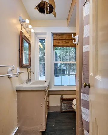 a bathroom with a sink a mirror and next to a window