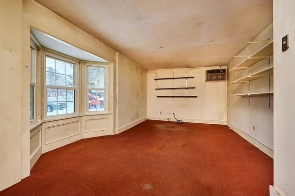 an empty room with windows and cabinet