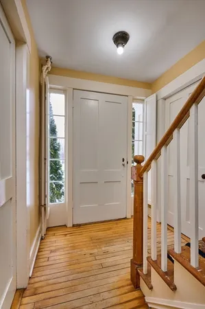 a view of an entryway with wooden floor and door