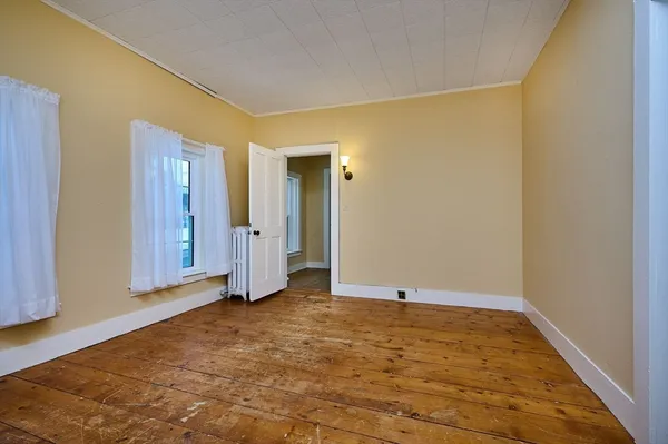 a view of a livingroom with wooden floor and a window