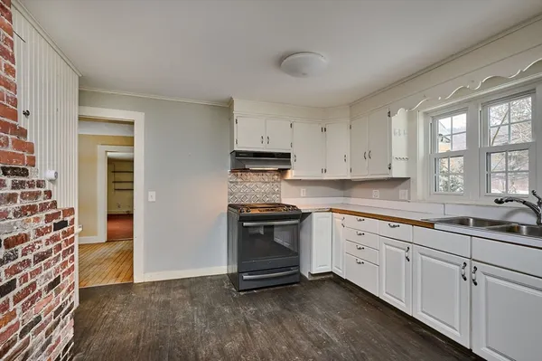 a kitchen with granite countertop white cabinets and stainless steel appliances