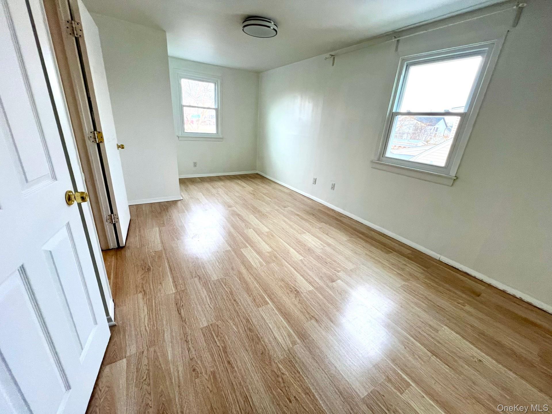 2341 Westley Road Westbury, NY 11590 - Photo 13 of 15 an empty room with wooden floor and windows