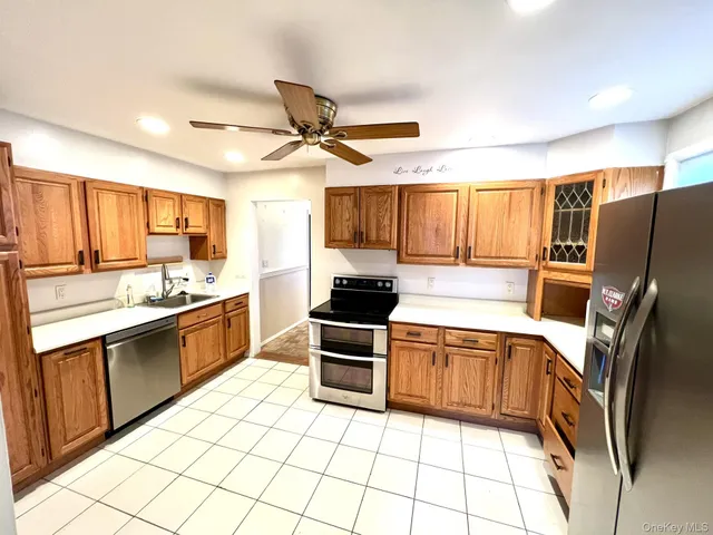 a kitchen with stainless steel appliances granite countertop a stove top oven a sink a dining table and chairs