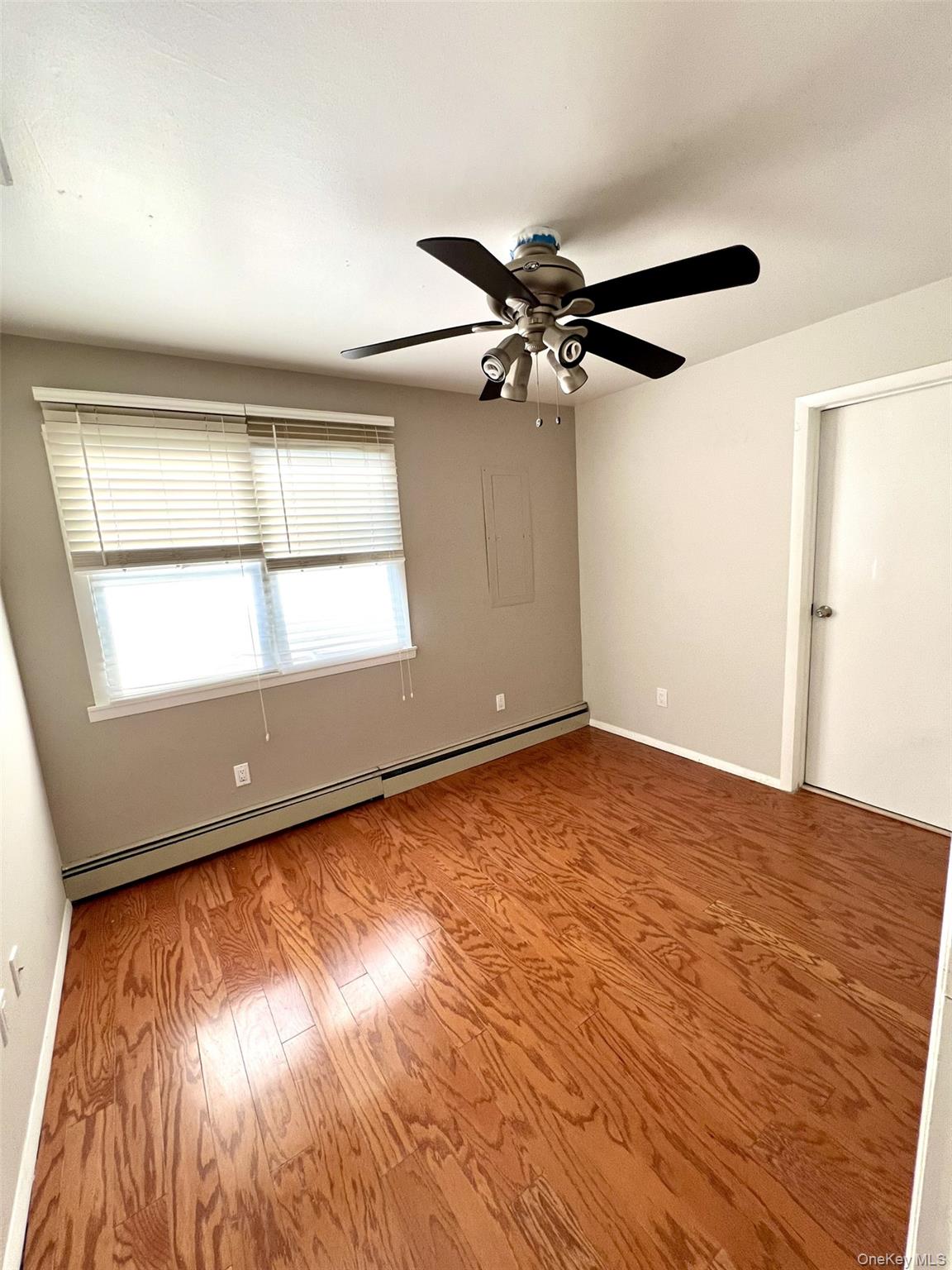 2341 Westley Road Westbury, NY 11590 - Photo 8 of 15 wooden floor in an empty room with a window