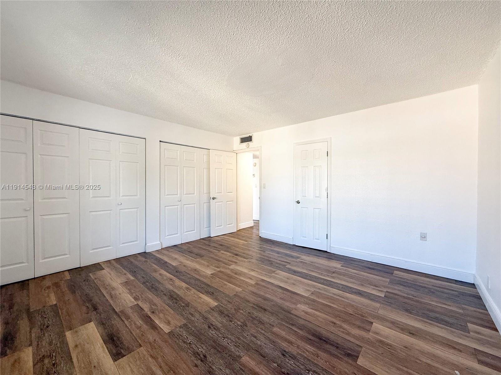 5231 Geneva Court, Unit 307 Doral, FL 33166 - Photo 11 of 26 a view of an empty room and wooden floor