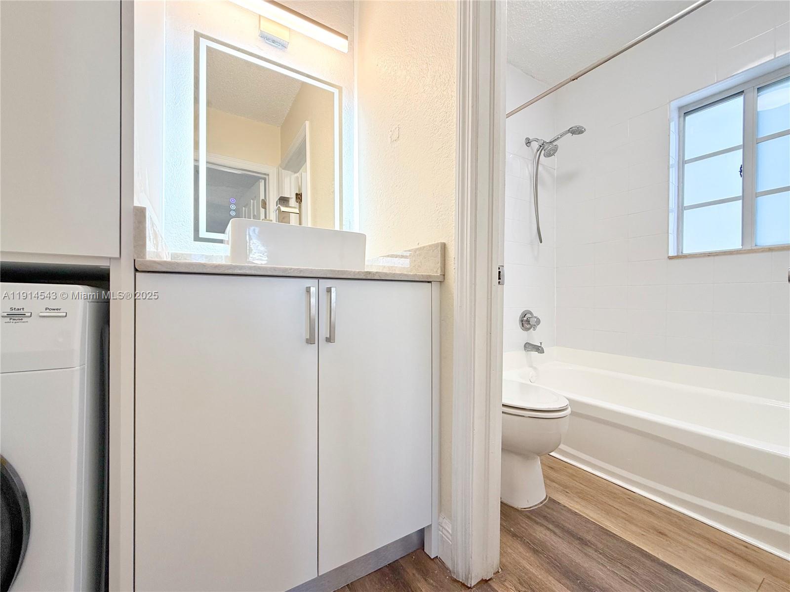5231 Geneva Court, Unit 307 Doral, FL 33166 - Photo 13 of 26 a bathroom with a granite countertop toilet a sink and a bathtub