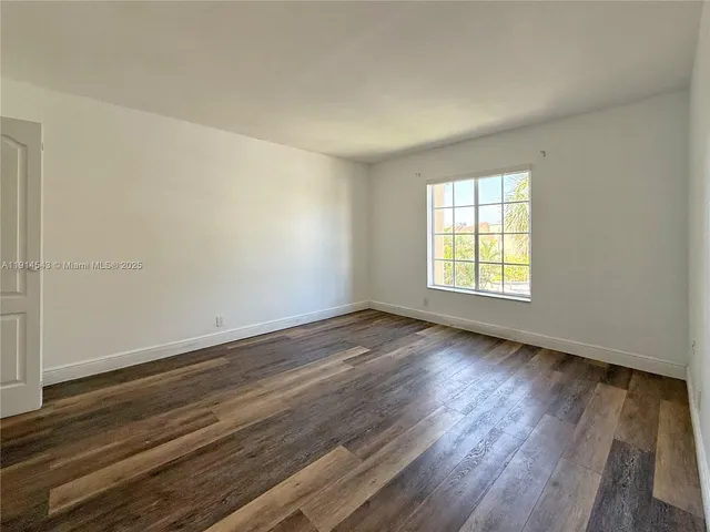 a view of a room with wooden floor and window