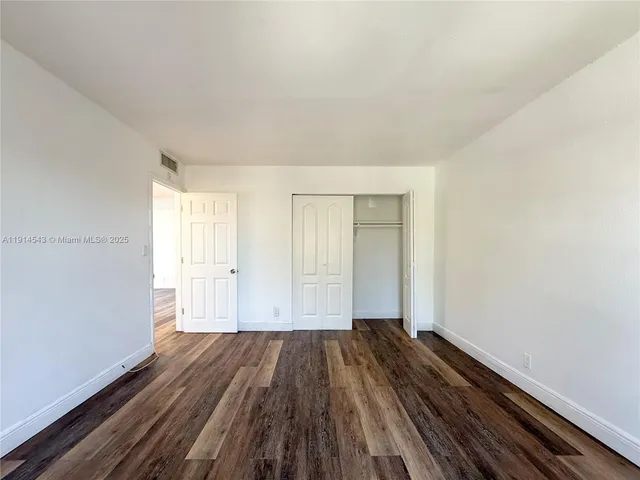 a view of an empty room and wooden floor