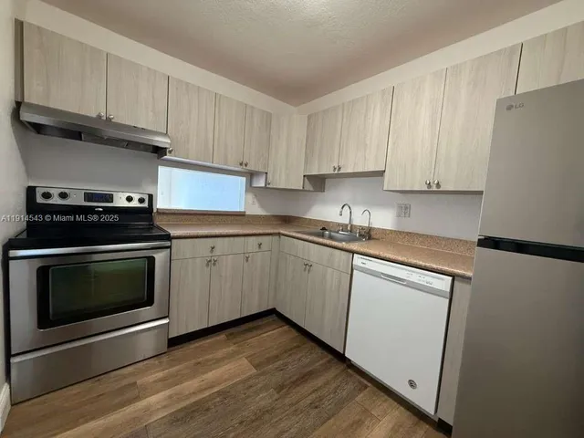a kitchen with granite countertop white cabinets and white appliances