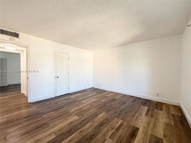 a view of an empty room and wooden floor