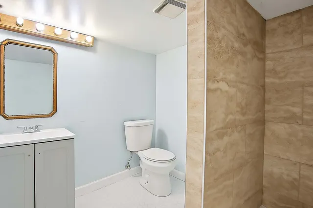 a bathroom with a toilet a sink and mirror
