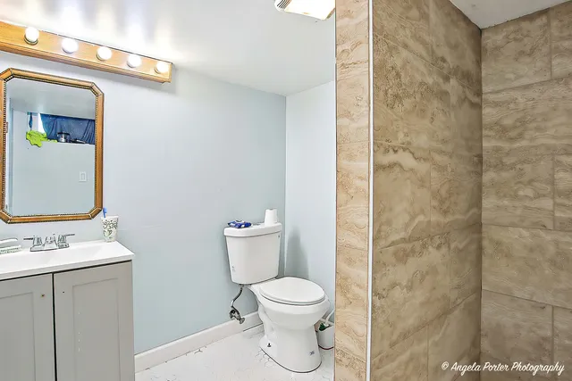 a bathroom with a toilet a sink and a mirror