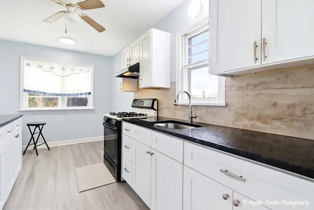 a kitchen with granite countertop white cabinets and white appliances