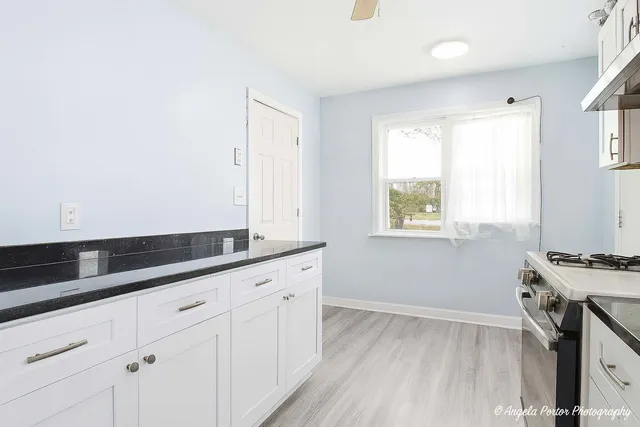 a kitchen with granite countertop white cabinets and white appliances