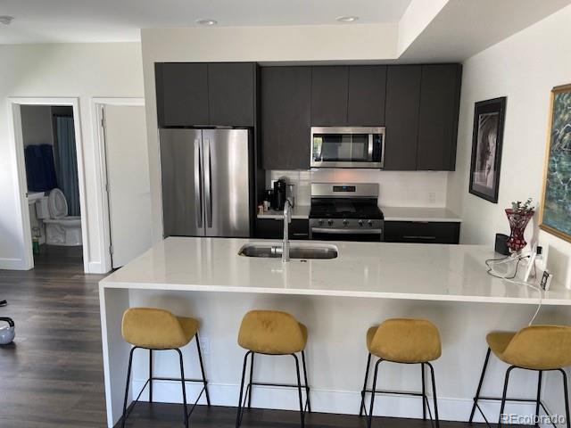 1204 South Reed Street Lakewood, CO 80232 - Photo 5 of 28 a kitchen with stainless steel appliances a dining table chairs and granite counter tops