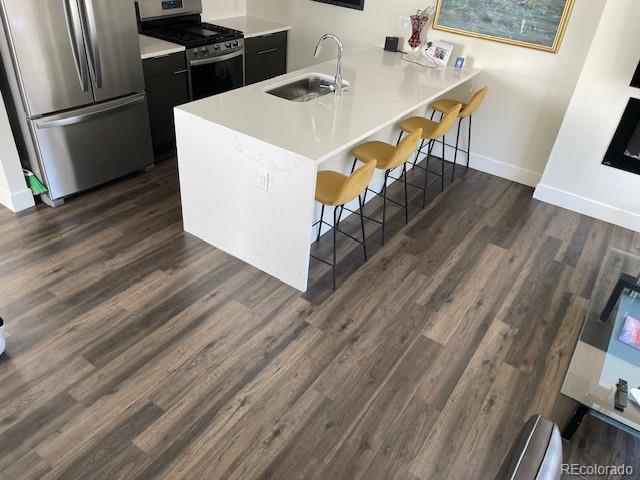 1204 South Reed Street Lakewood, CO 80232 - Photo 8 of 28 a kitchen with kitchen island a stove a sink and a refrigerator