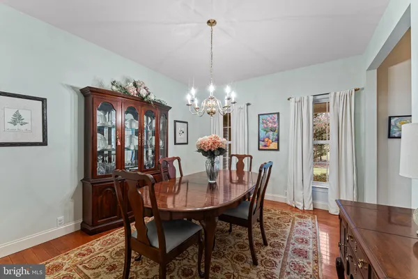 a dining room with furniture a chandelier and wooden floor