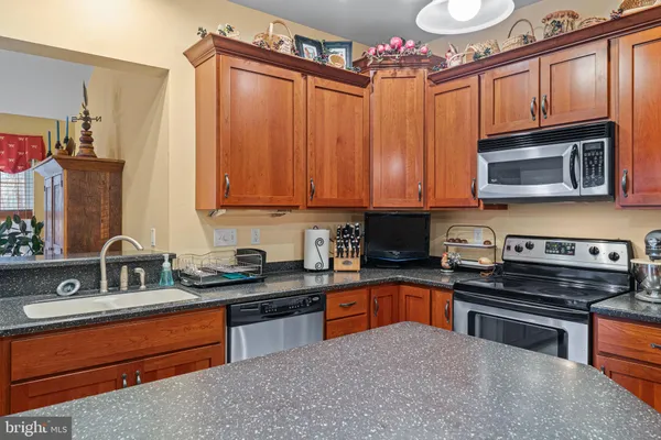 a kitchen with stainless steel appliances granite countertop a stove microwave and sink