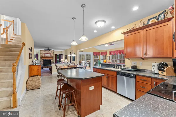 a kitchen with stainless steel appliances granite countertop a sink a stove and a wooden floors