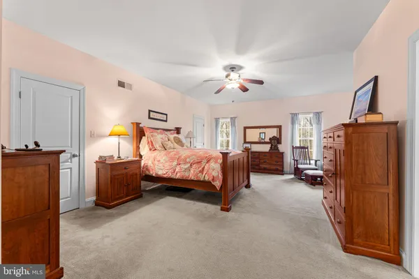 a bedroom with a bed dresser and wooden floor