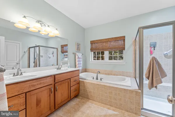 a bathroom with a tub a sink and a mirror