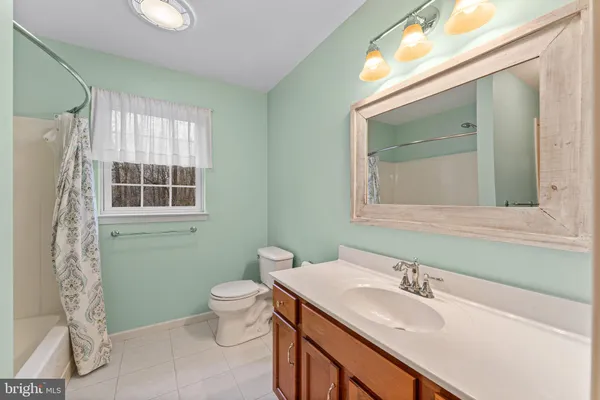 a bathroom with a granite countertop sink toilet and mirror