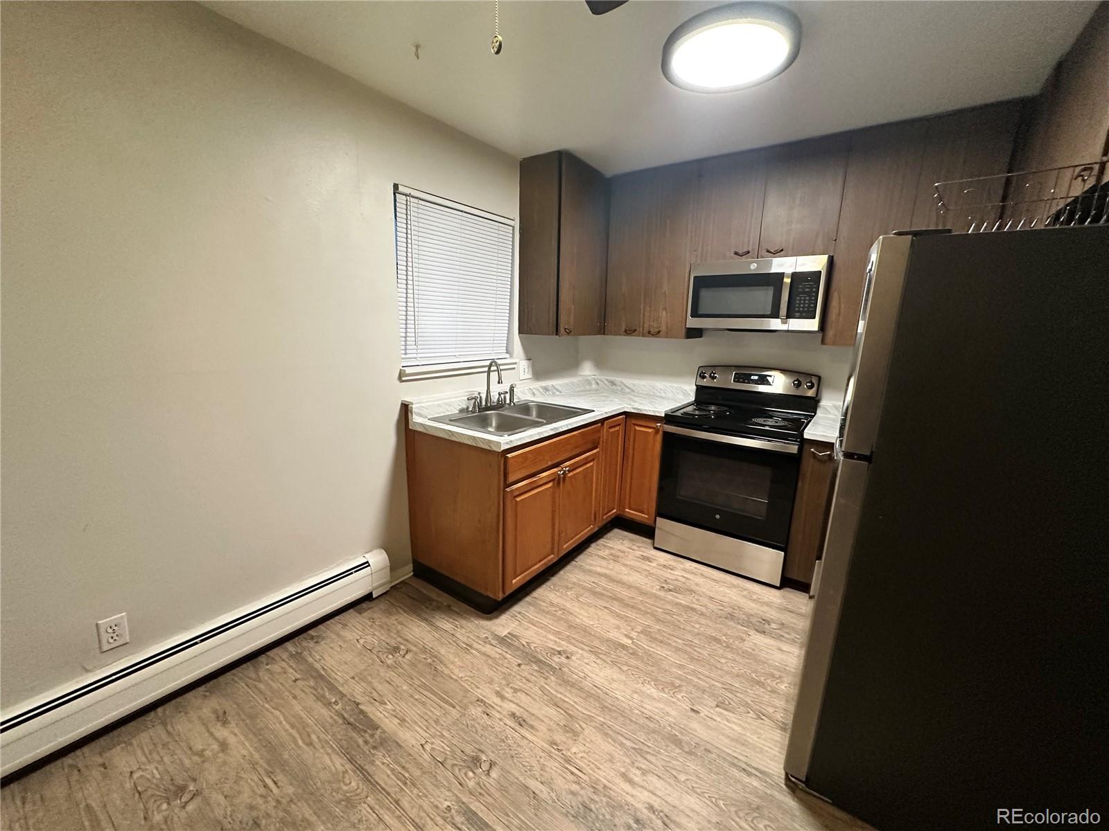 6190 Webster Street Arvada, CO 80003 - Photo 2 of 6 a kitchen with stainless steel appliances granite countertop a stove a refrigerator and a sink