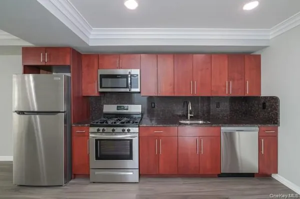 a kitchen with granite countertop a refrigerator stove and microwave