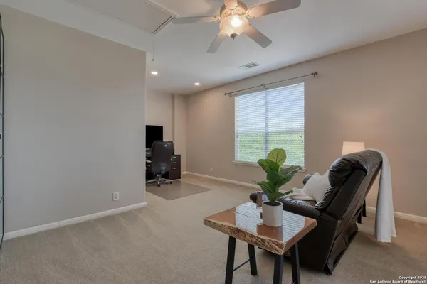 a living room with furniture and a ceiling fan
