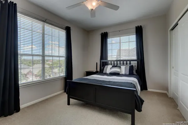 a view of a backyard with couches table and chairs with wooden fence and plants