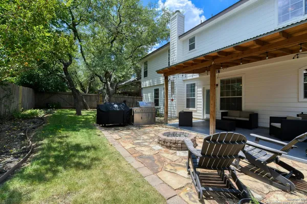 a view of a house with backyard and sitting area
