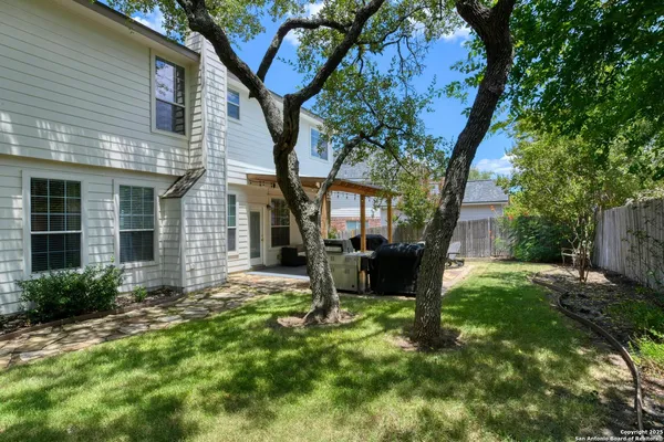 a front view of a house with a garden and trees
