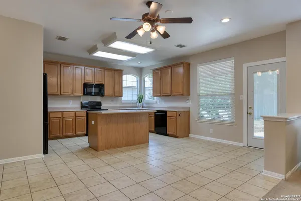 a kitchen with kitchen island granite countertop a stove sink and cabinets