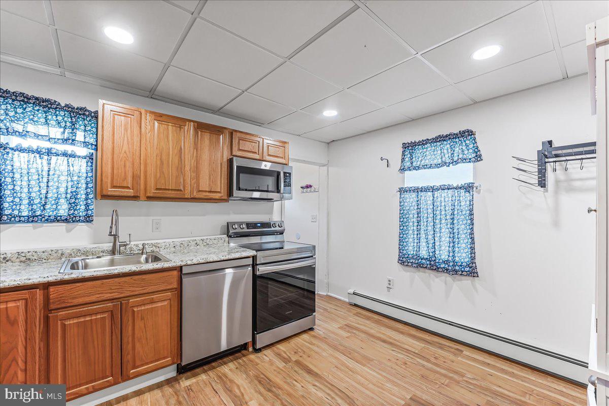 632 Taylor Avenue Upper Chichester, PA 19061 - Photo 9 of 20 a kitchen with stainless steel appliances granite countertop a stove a sink dishwasher and a microwave oven with wooden floor