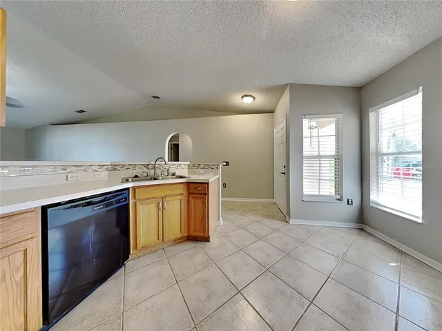 a open kitchen with a stove top oven sink and cabinets