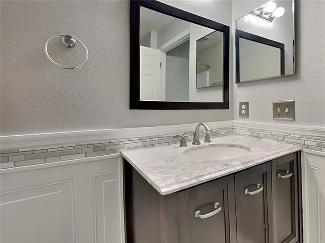 a bathroom with a granite countertop sink and a mirror